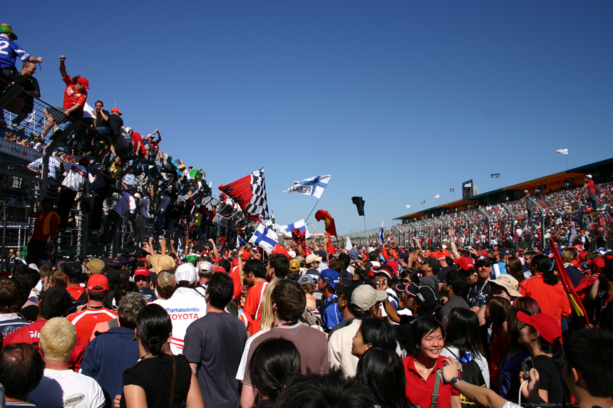 Fans (and me) on the race track right after the race to get a glimpse of the drivers getting on the podium and celebrating